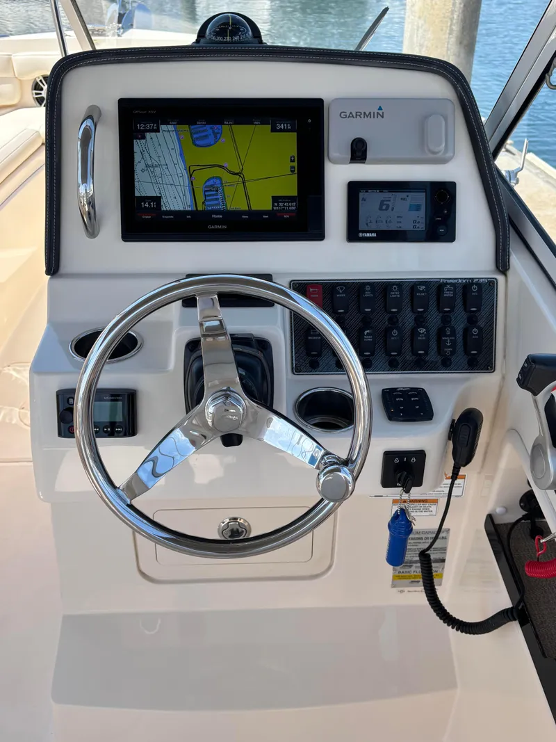 Slide: The Image of 2017 Grady-White Freedom 235 boat dashboard with Garmin navigation system and steering wheel. - 22