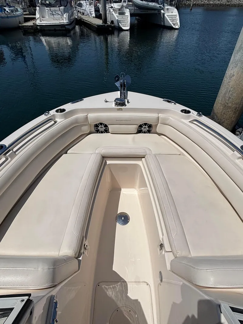 Slide: The Image of 2017 Grady-White Freedom 235 boat interior with cushioned seating, docked in marina. - 25