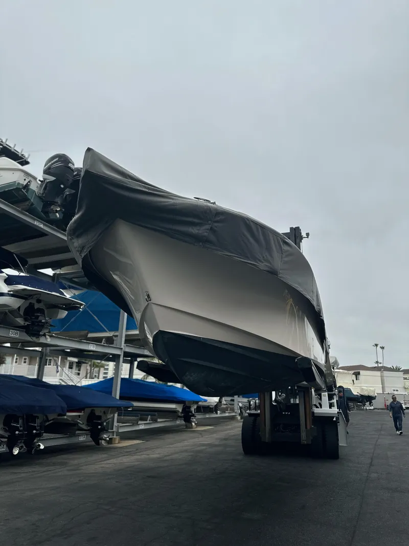 Slide: The Image of 2017 Grady-White Freedom 235 boat on a forklift in a marina storage area. - 28