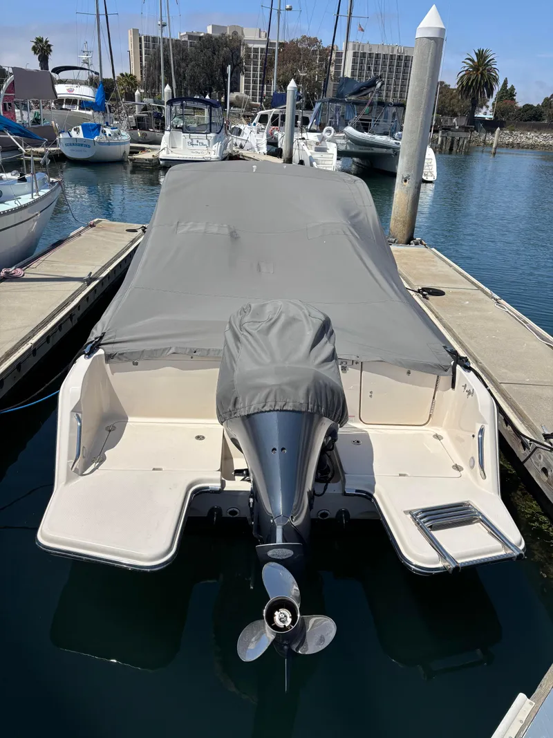 Slide: The Image of 2017 Grady-White Freedom 235 boat docked with cover, marina background. - 30