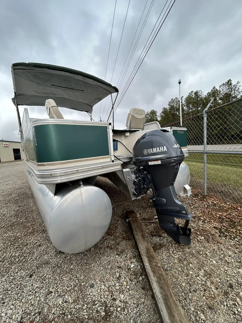 Slide: The Image of 2000 Fisher Freedom 200 DLX pontoon boat with Yamaha outboard motor, parked on gravel. - 3