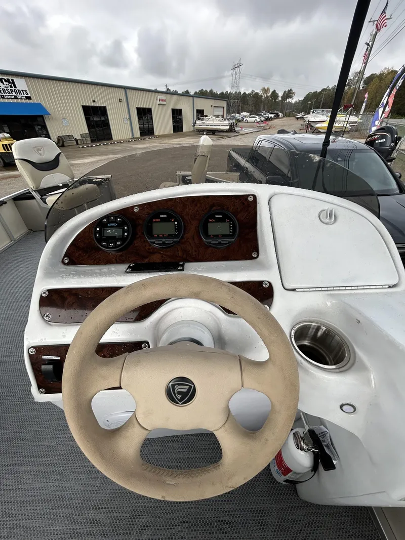 Slide: The Image of Steering console of a 2000 Fisher Freedom 200 DLX boat, featuring gauges and controls. - 8