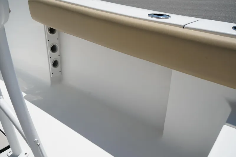 Slide: The Image of 2016 Sportsman Heritage 211 Center Console interior detail with beige padding and rod holders. - 14