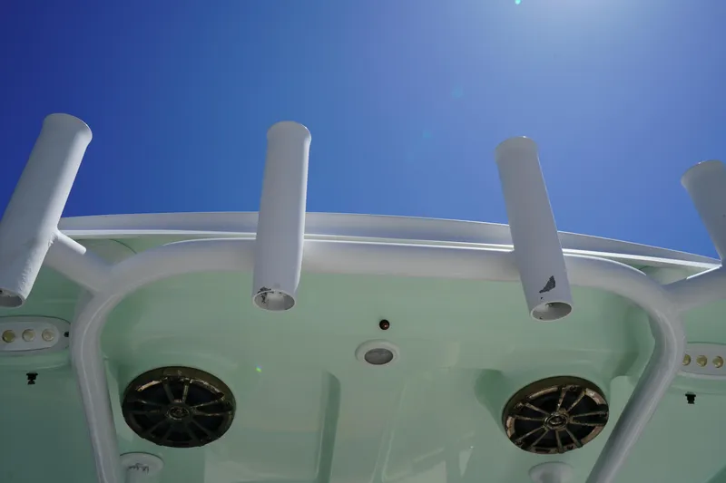 Slide: The Image of 2016 Sportsman Heritage 211 Center Console boat, rod holders, and speakers under clear blue sky. - 15