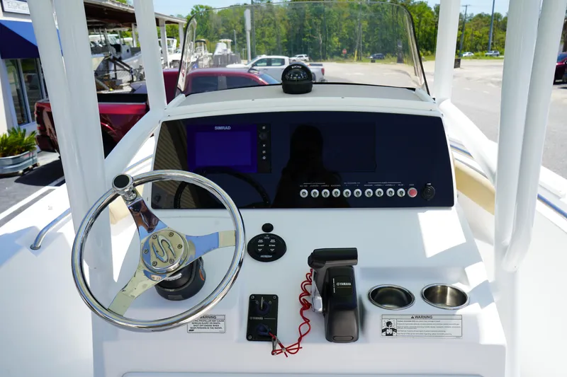 Slide: The Image of 2016 Sportsman Heritage 211 Center Console boat dashboard with steering wheel and navigation controls. - 18