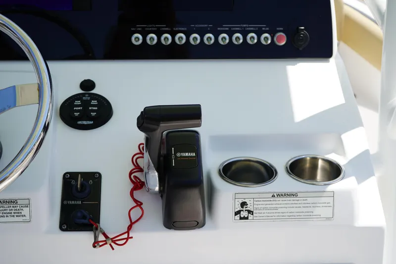 Slide: The Image of Center console controls of 2016 Sportsman Heritage 211 boat with Yamaha throttle and cup holders. - 21