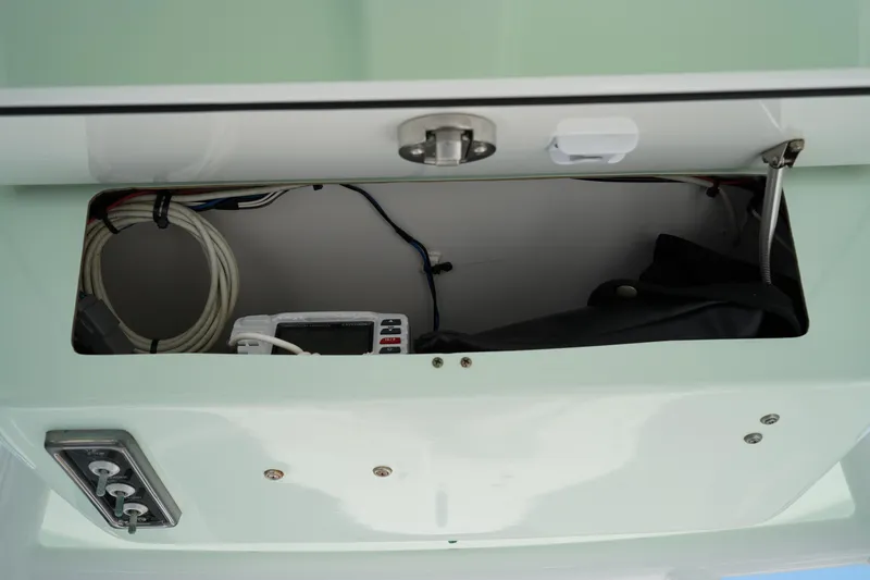 Slide: The Image of Storage compartment of a 2016 Sportsman Heritage 211 Center Console boat, showing cables and equipment. - 27