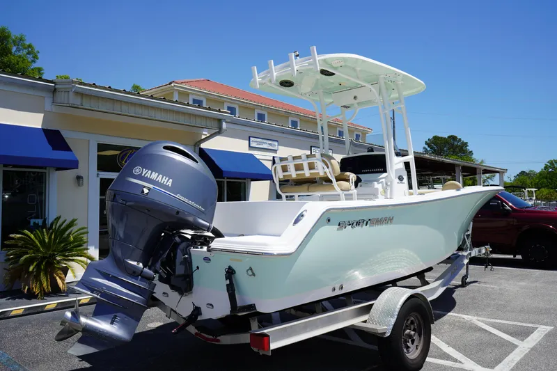 Slide: The Image of 2016 Sportsman Heritage 211 Center Console boat on trailer, parked outside a building. - 6