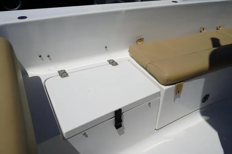 Slide: The Image of 2016 Sportsman Heritage 211 Center Console boat interior with cushioned seating and storage compartment. - 9