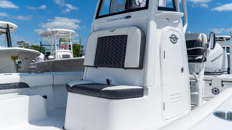 Slide: The Image of 2025 Tidewater 2500 Carolina Bay boat, white exterior, black seating, under clear blue sky. - 22