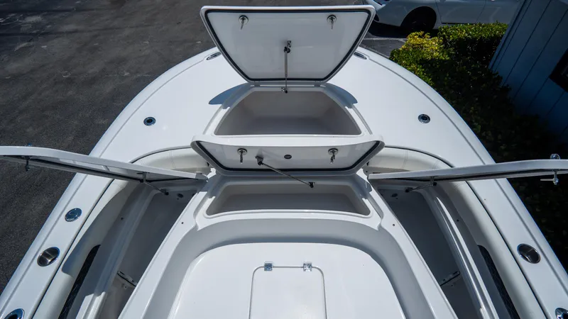 Slide: The Image of 2025 Tidewater 2500 Carolina Bay boat with open storage compartments on deck. - 24