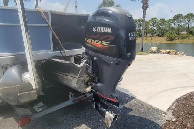 Slide: The Image of 2016 Bennington 21SFX boat with Yamaha VMAX 150 outboard motor, parked near a lake. - 3