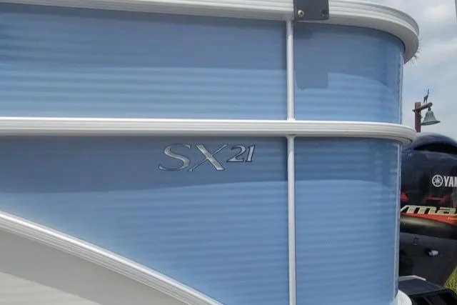 Slide: The Image of 2016 Bennington 21SFX boat, blue exterior with SX21 logo, partial view. - 8