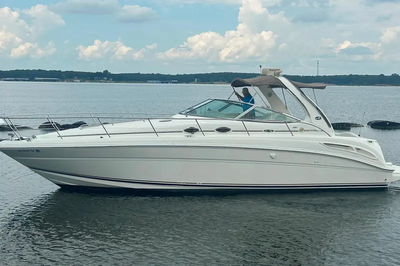 The Image of 2002 Sea Ray 360 Sundancer yacht cruising on a calm lake under a cloudy sky. - 0