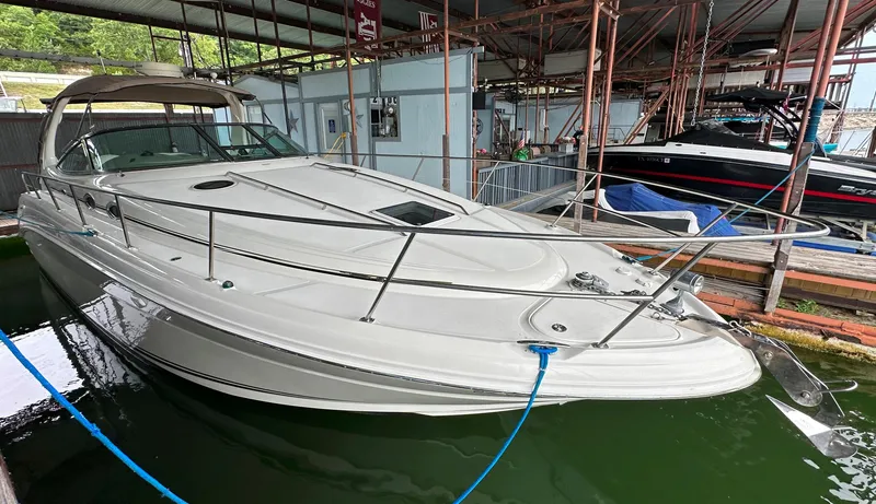 Slide: The Image of 2002 Sea Ray 360 Sundancer docked in a marina, showcasing sleek design and spacious deck. - 13