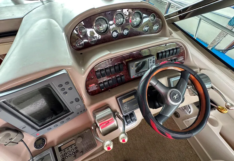 Slide: The Image of 2002 Sea Ray 360 Sundancer helm with gauges, controls, and steering wheel. - 26