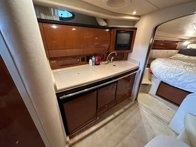 Slide: The Image of Luxurious 2002 Sea Ray 360 Sundancer yacht interior with kitchenette and cozy bedroom. - 36
