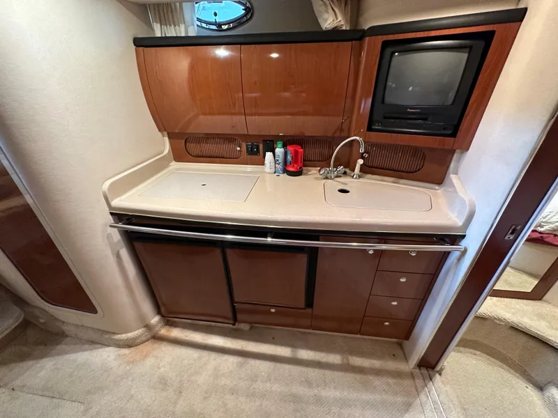 Slide: The Image of 2002 Sea Ray 360 Sundancer galley with wood cabinetry, sink, and built-in TV. - 37