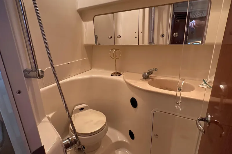 Slide: The Image of 2002 Sea Ray 360 Sundancer bathroom with sink, toilet, and mirrored cabinets. - 52