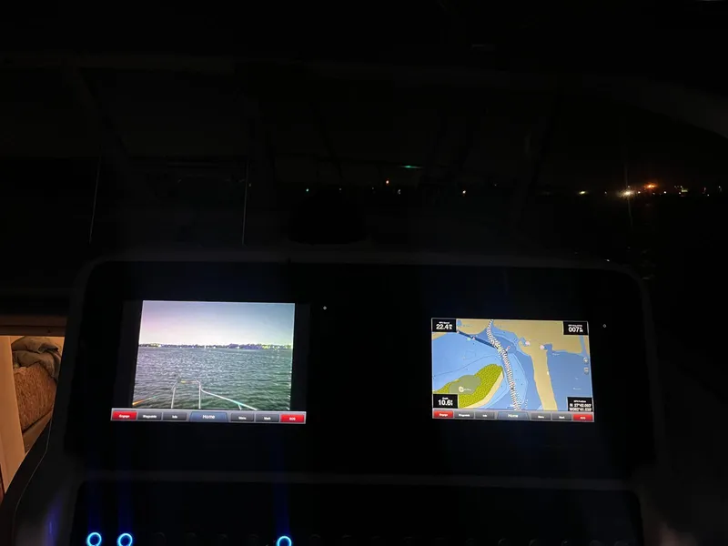 Slide: The Image of Dashboard of a 2005 Pro-Line 32 Express boat with navigation screens at night. - 12