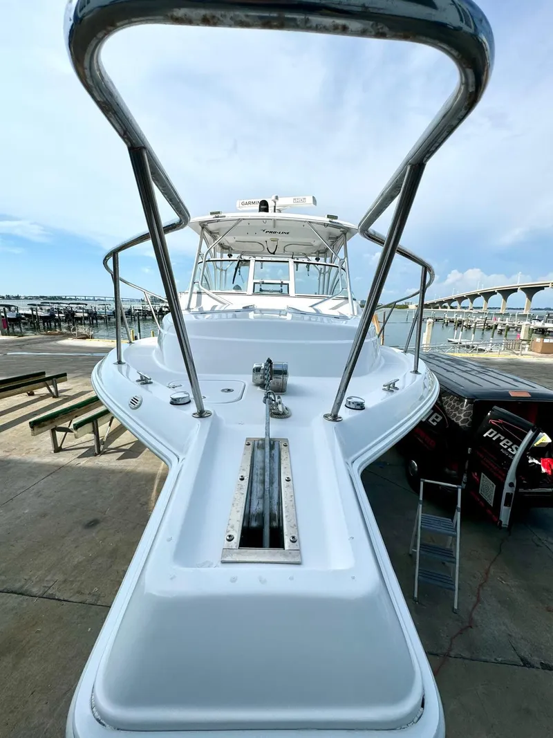 Slide: The Image of 2005 Pro-Line 32 Express boat docked, showcasing sleek design and spacious deck. - 15