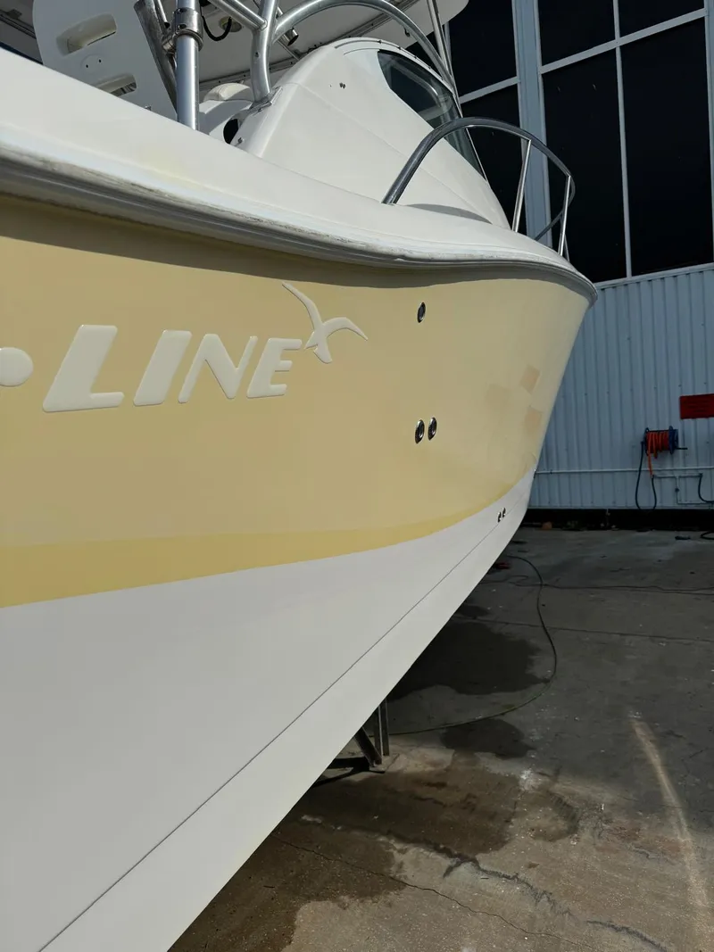 Slide: The Image of 2005 Pro-Line 32 Express boat, yellow and white hull, docked outdoors. - 16