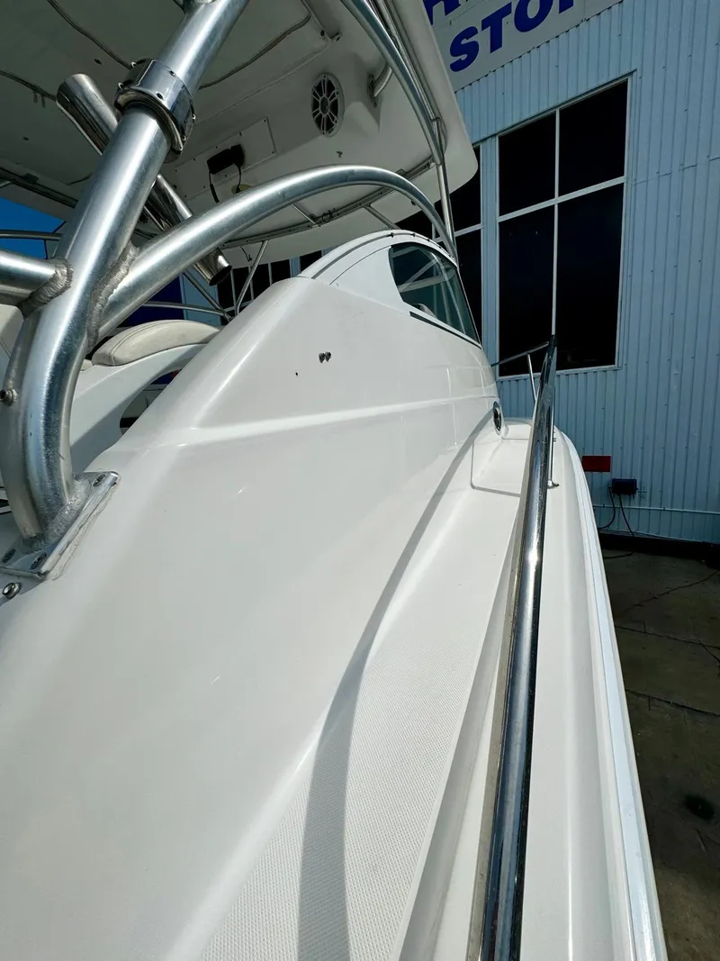 Slide: The Image of 2005 Pro-Line 32 Express boat, sleek design, docked near a building. - 17