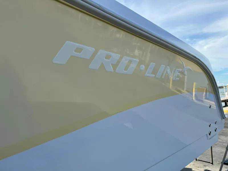 Slide: The Image of 2005 Pro-Line 32 Express boat side view with logo, under a clear blue sky. - 2