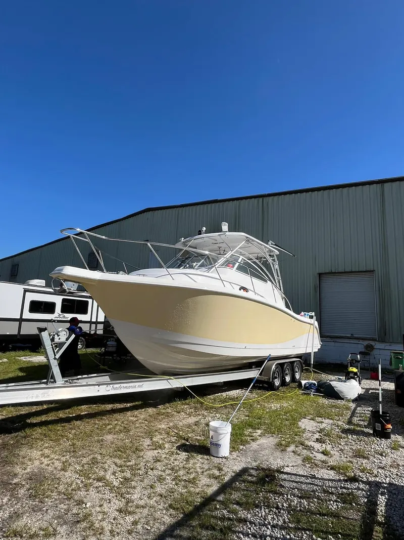 Slide: The Image of 2005 Pro-Line 32 Express boat on trailer, parked outdoors near a large building. - 3