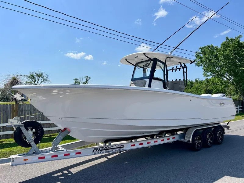 Slide: The Image of 2025 Sea Hunt Gamefish 30 with Coffin Box on trailer, under clear blue sky. - 1