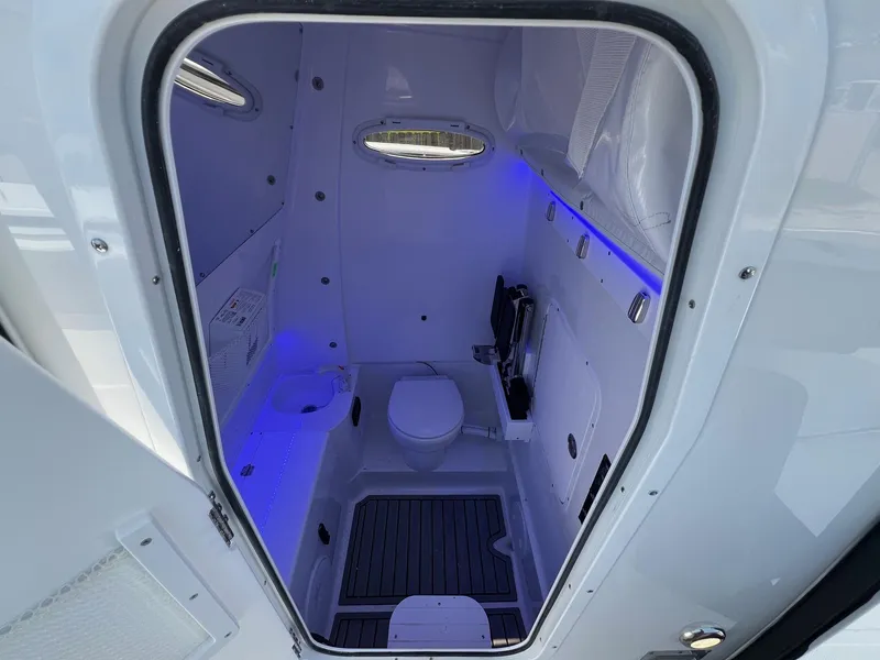 Slide: The Image of 2025 Sea Hunt Gamefish 30 boat interior with modern bathroom and blue LED lighting. - 19