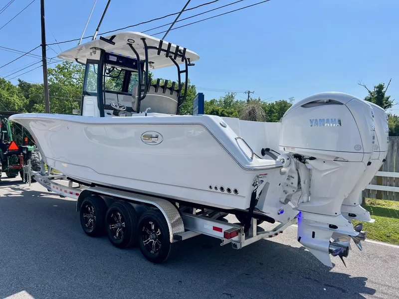 Slide: The Image of 2025 Sea Hunt Gamefish 30 with Coffin Box on trailer, featuring Yamaha outboard engines. - 2