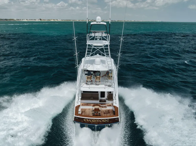 Slide: The Image of 2009 Hatteras 60GT yacht cruising on open sea, rear view, with wake trails. - 2