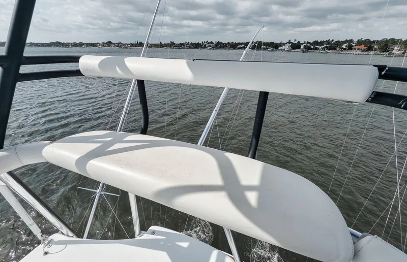 Slide: The Image of 2009 Hatteras 60GT yacht deck view with railing, overlooking calm waters and distant shoreline. - 27