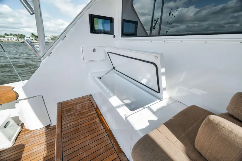 Slide: The Image of 2009 Hatteras 60GT yacht deck with open storage compartment and wooden flooring. - 40