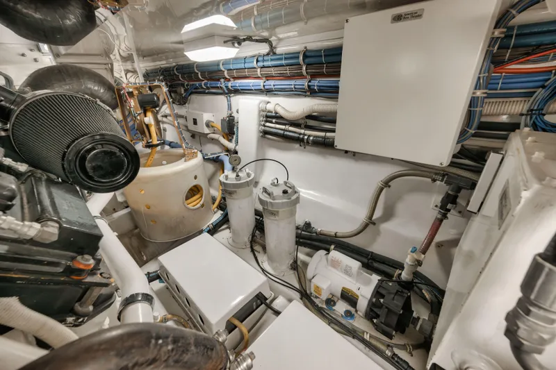 Slide: The Image of Engine room of 2009 Hatteras 60GT yacht, showcasing mechanical components and wiring. - 46