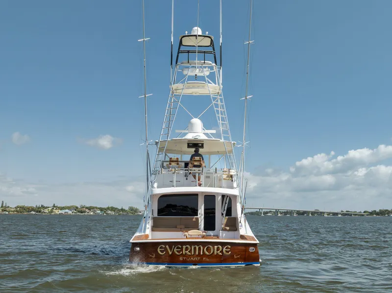 Slide: The Image of 2009 Hatteras 60GT yacht "Evermore" cruising on open water under a clear blue sky. - 8