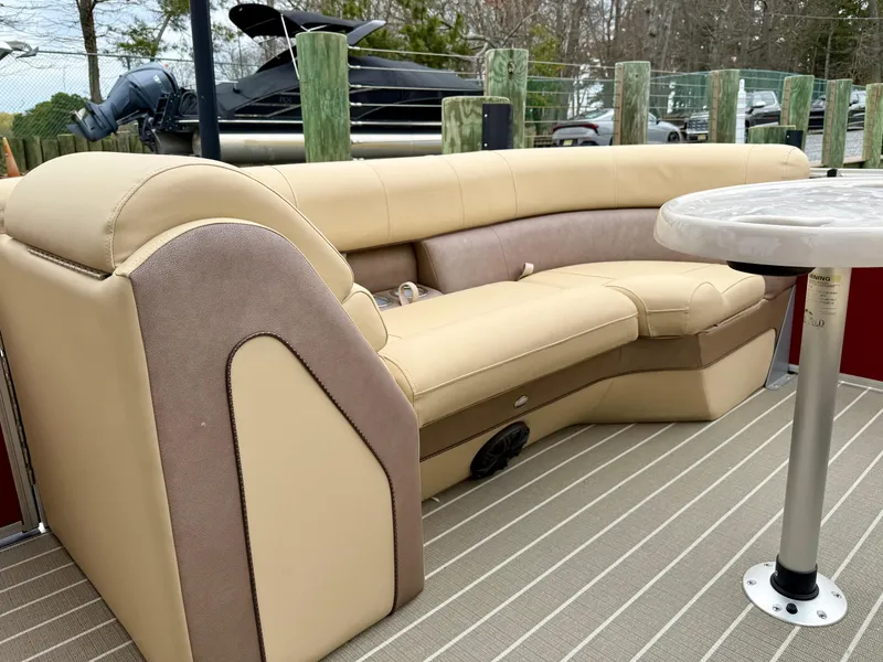 Slide: The Image of 2019 Bentley Pontoons 223 Elite interior with beige seating and table. - 10