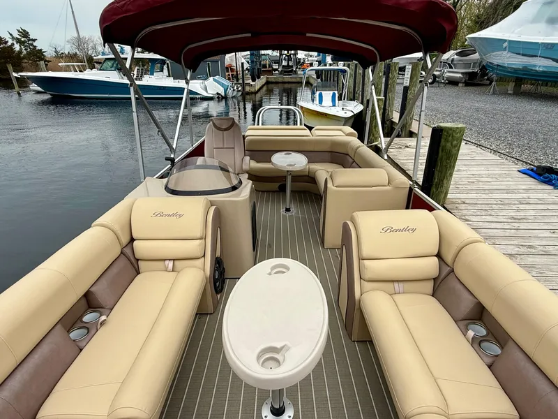 Slide: The Image of 2019 Bentley Pontoons 223 Elite with beige seating and red canopy docked at marina. - 12