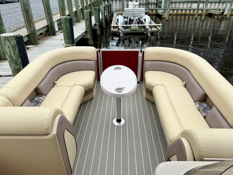 Slide: The Image of 2019 Bentley Pontoons 223 Elite with beige seating and table, docked at a marina. - 7