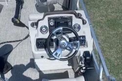 Slide: The Image of Steering console of 2021 Avalon VTX Quad Fish boat, featuring modern controls and design. - 2