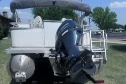 Slide: The Image of 2021 Avalon VTX Quad Fish boat with Yamaha outboard motor, parked on grass. - 5