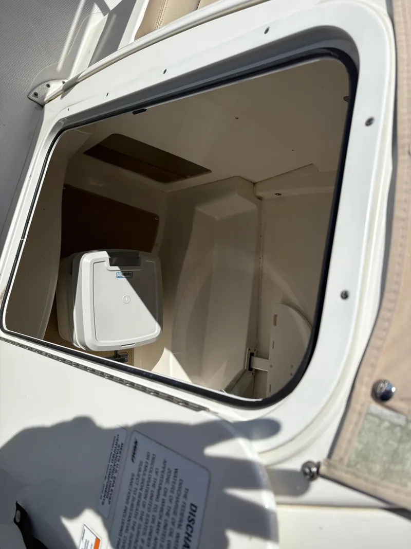 Slide: The Image of 2017 Sailfish 236 CC boat storage compartment with open hatch, showcasing interior space. - 12