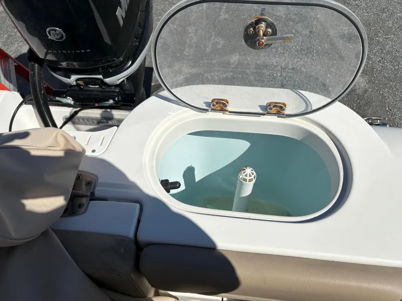 Slide: The Image of Livewell on 2017 Sailfish 236 CC boat, open lid, with Mercury engine visible. - 15