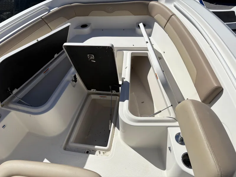 Slide: The Image of 2017 Sailfish 236 CC boat interior with open storage compartments and beige seating. - 22