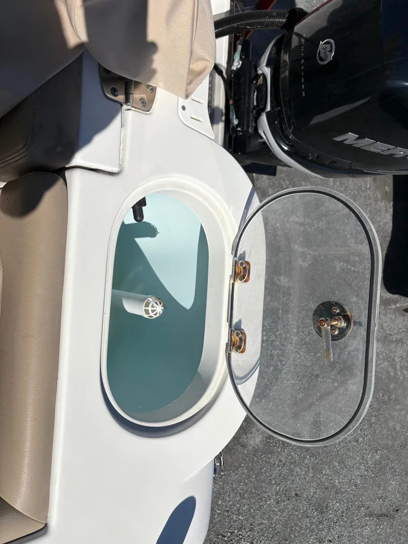 Slide: The Image of 2017 Sailfish 236 CC boat livewell with open lid, showcasing interior details. - 23