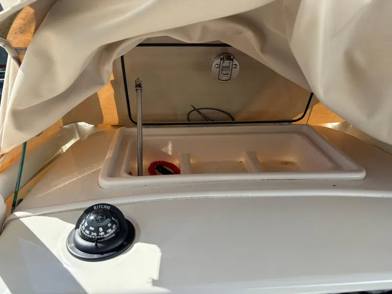 Slide: The Image of 2017 Sailfish 236 CC boat dashboard with compass and storage compartment. - 7