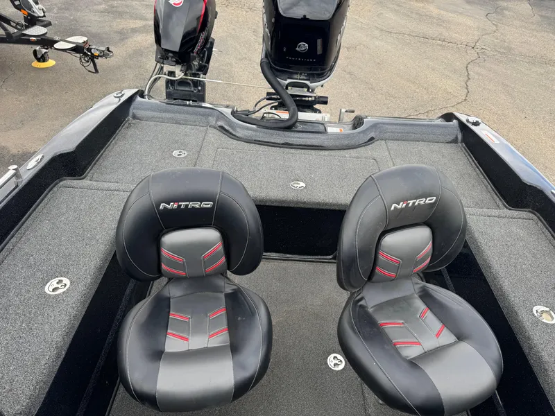 Slide: The Image of Two black and red Nitro ZV21 boat seats, 2019 model, on a carpeted surface. - 13