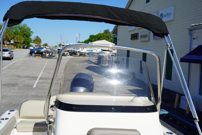 Slide: The Image of 2023 Key West 189 FS boat with windshield and canopy in a marina setting. - 19