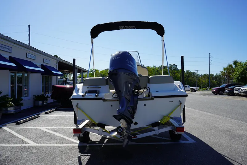 Slide: The Image of 2023 Key West 189 FS boat with outboard motor in parking lot. - 6